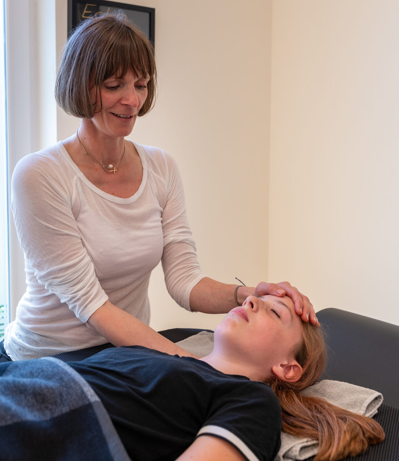 Arleta führt craniosacrale Behandlung an liegendem Klienten durch